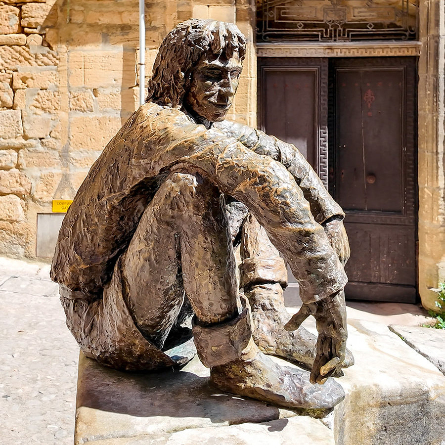 Rue d'un village en Dordogne avec une statue